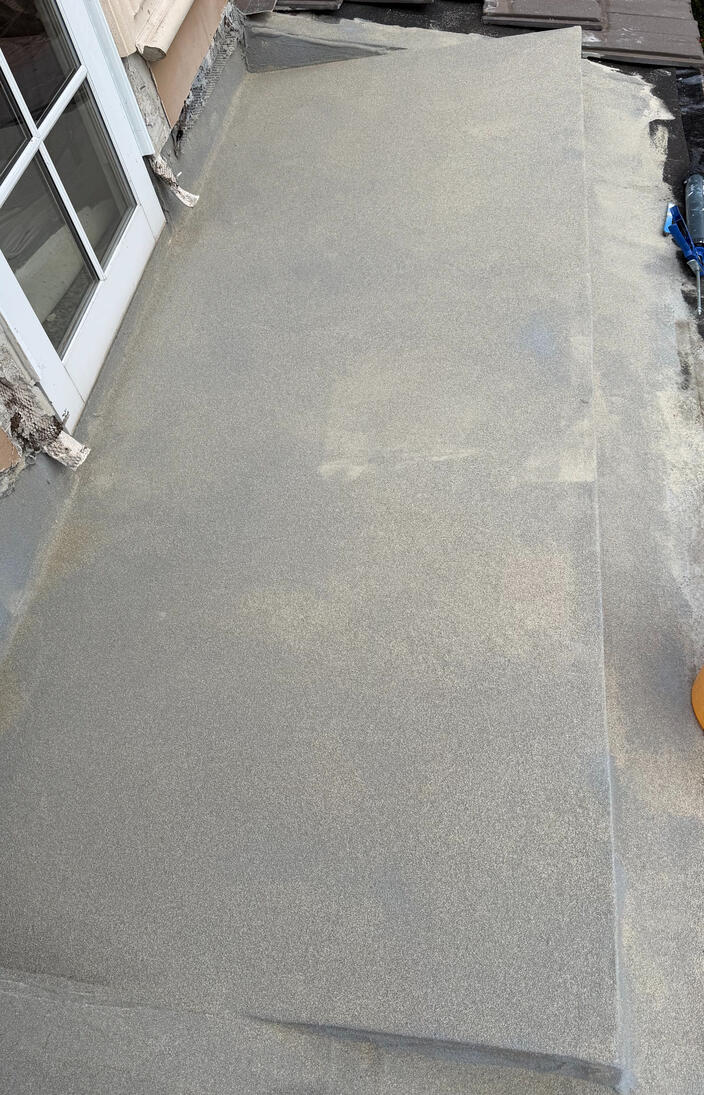 This restoration solution features a UV-resistant aliphatic finish textured with sand aggregate for tile installation. The repair is structurally reinforced with polyamide mesh and elastomeric sealants to permanently bridge cracks and prevent future leaks.